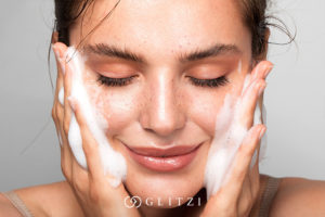 Mujer lavando rostro antes de maquillarse